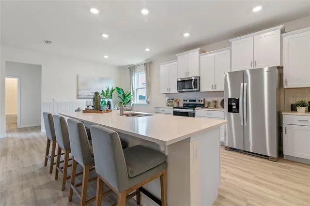 a kitchen with kitchen island granite countertop a refrigerator and a stove top oven