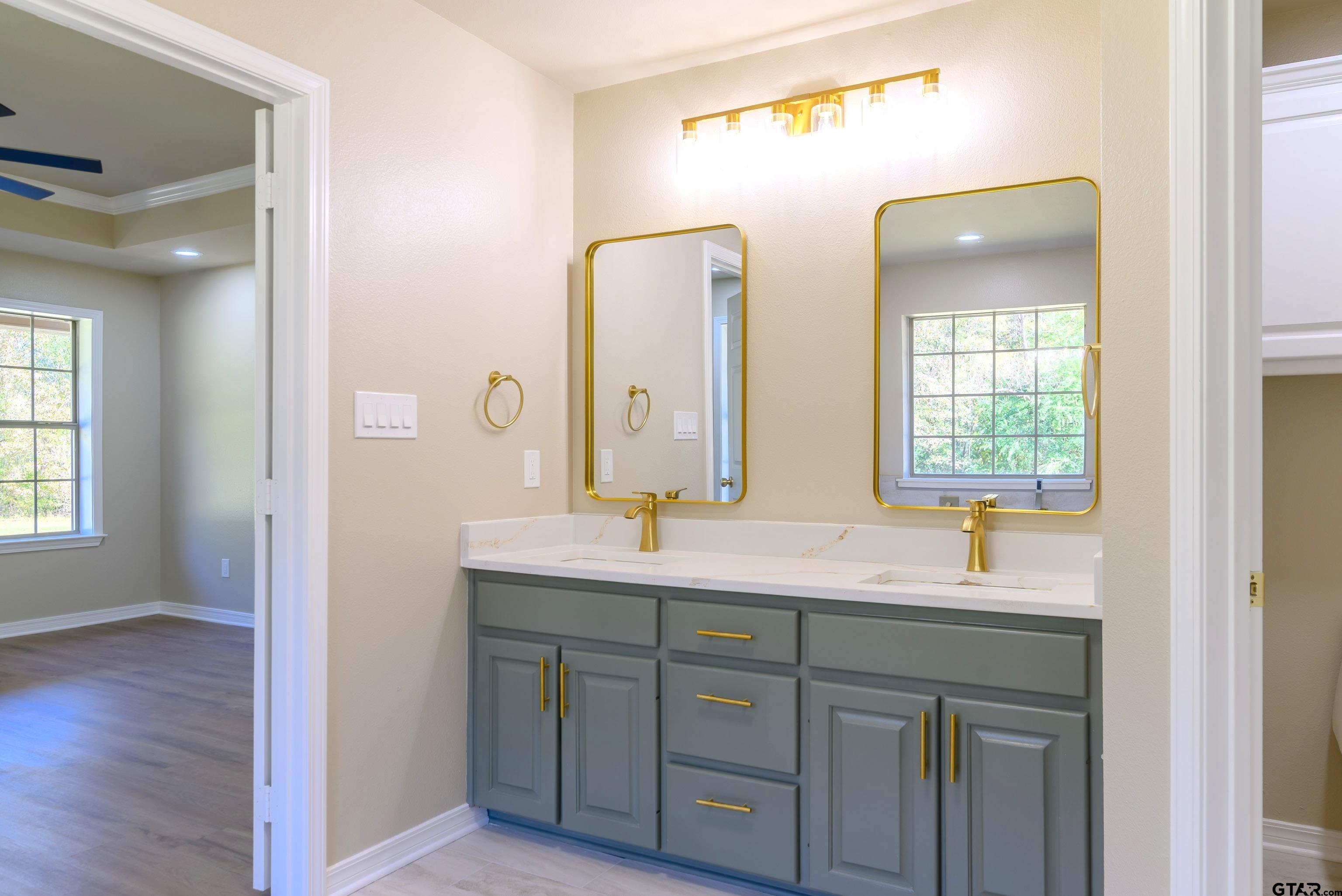 7589 Weeping Willow Road Big Sandy, TX 75755 - Photo 19 of 48 a bathroom with a double vanity sink and mirror with window