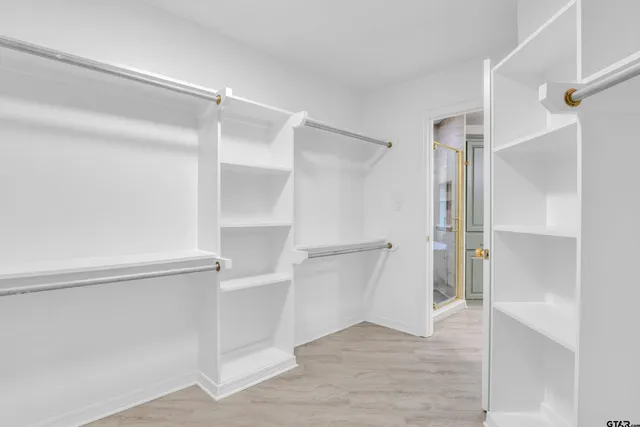 a view of walk in closet with empty racks