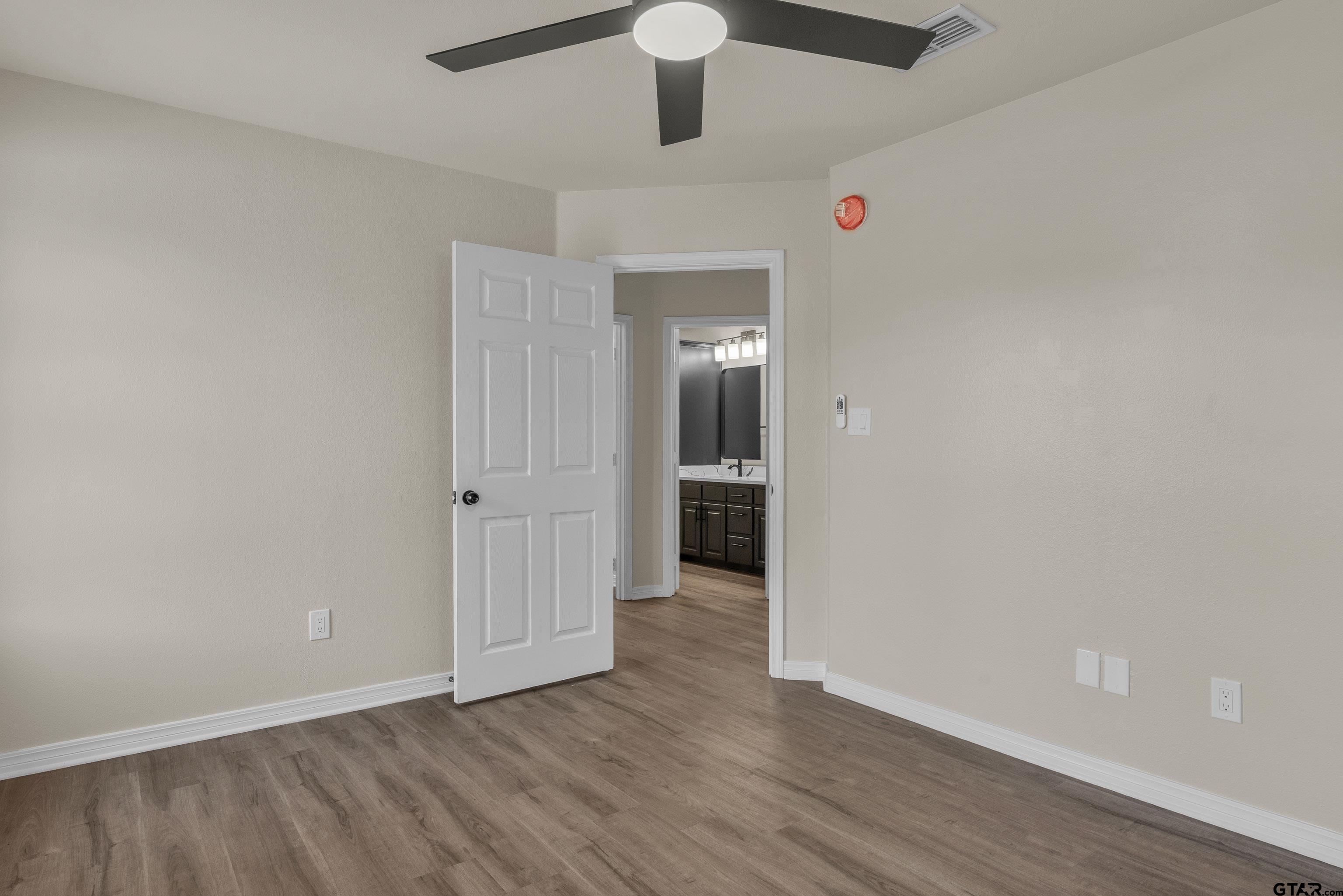 7589 Weeping Willow Road Big Sandy, TX 75755 - Photo 29 of 48 a view of a hallway with wooden floor and chandelier