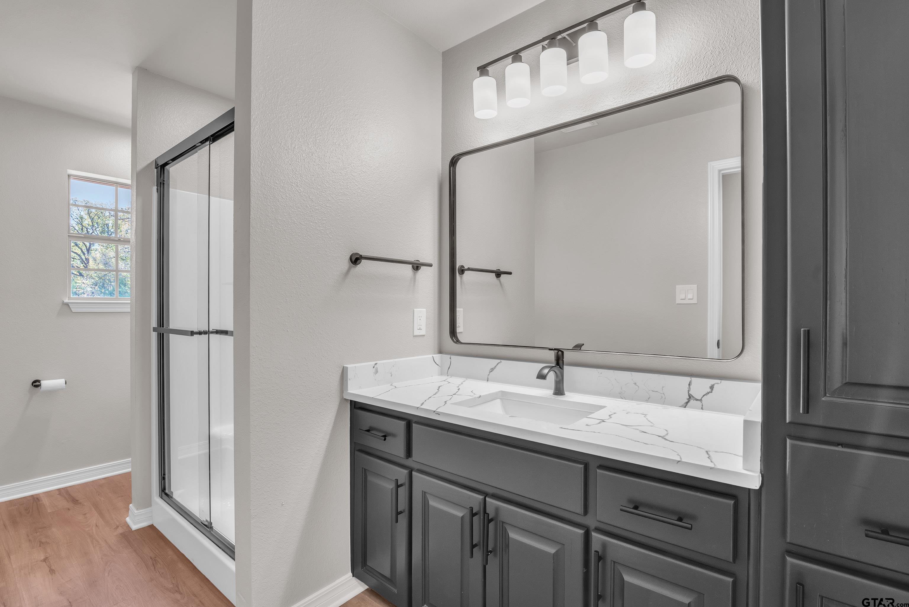 7589 Weeping Willow Road Big Sandy, TX 75755 - Photo 36 of 48 a bathroom with a granite countertop sink and a mirror