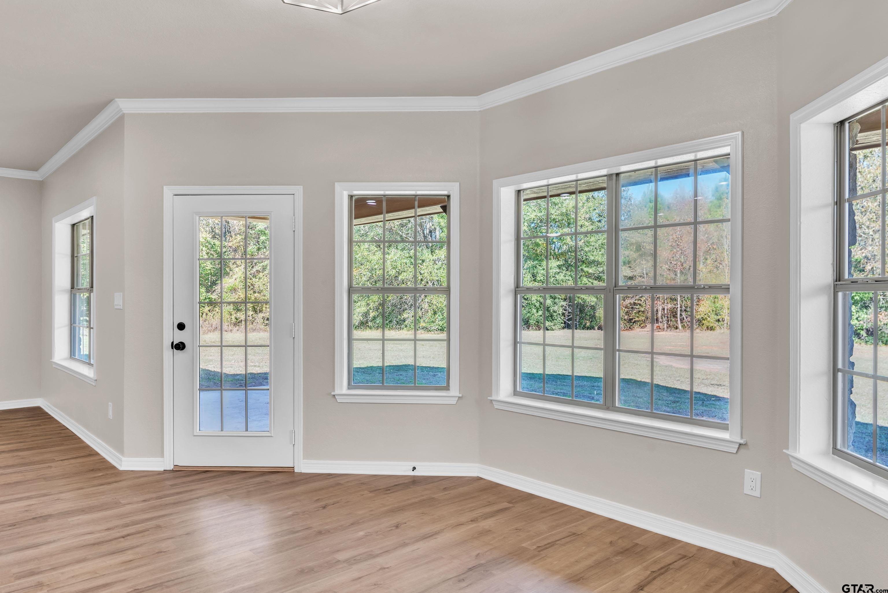 7589 Weeping Willow Road Big Sandy, TX 75755 - Photo 8 of 48 a view of an empty room with wooden floor and a window