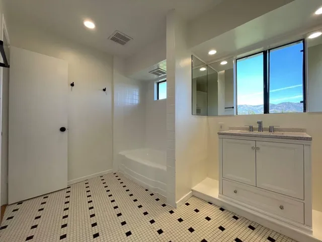 a bathroom with a sink a large mirror and shower