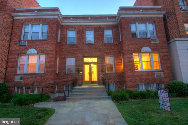 a view of building with yard and parking spaces