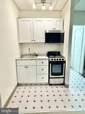a kitchen with stainless steel appliances a stove a sink and a microwave