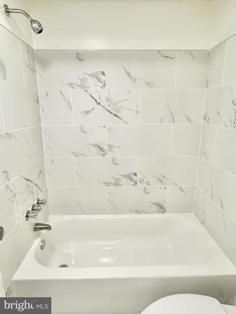 a white toilet and tub sitting next to a bathroom sink