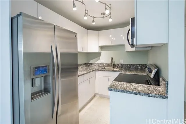 a kitchen with stainless steel appliances granite countertop a refrigerator a sink and a stove