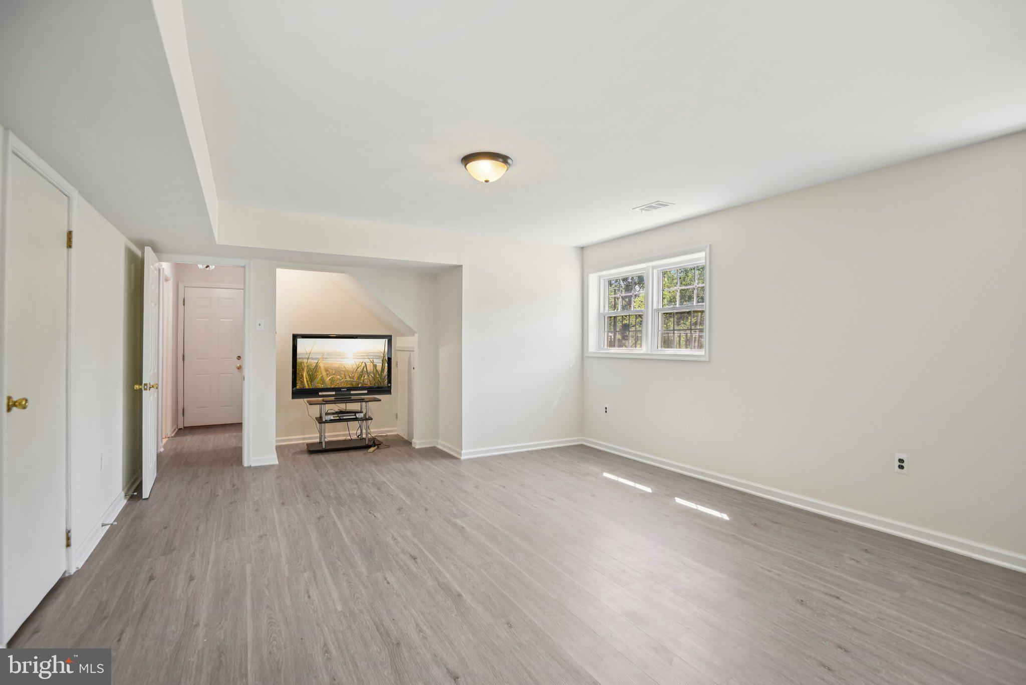 1005 Kings Tree Drive Bowie, MD 20721 - Photo 23 of 71 a view of a livingroom with wooden floor and a flat screen tv