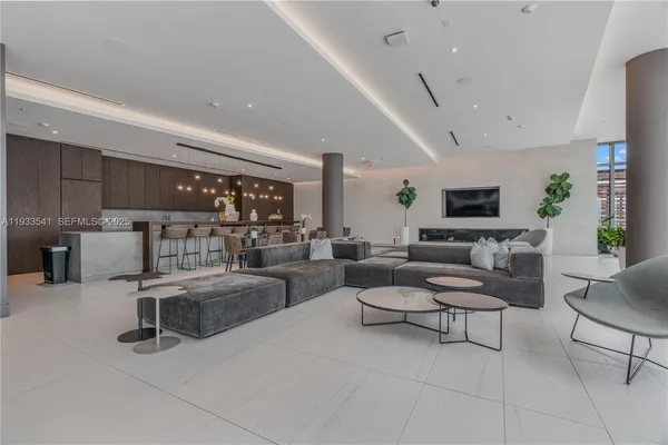 a living room with lots of furniture and view of kitchen