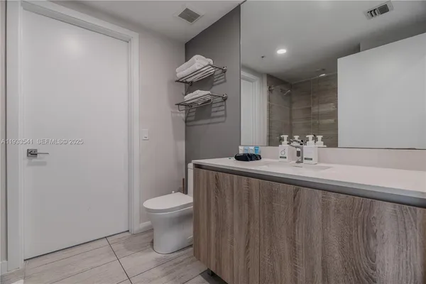 a bathroom with a sink a toilet and mirror