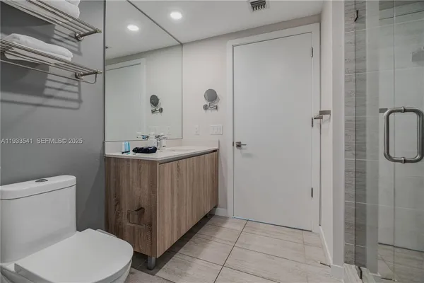 a bathroom with a sink a toilet and shower