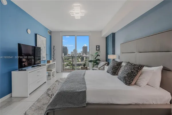a bedroom with a large bed and a flat screen tv