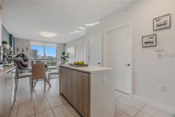 a kitchen with kitchen island a counter top space and a view of living room
