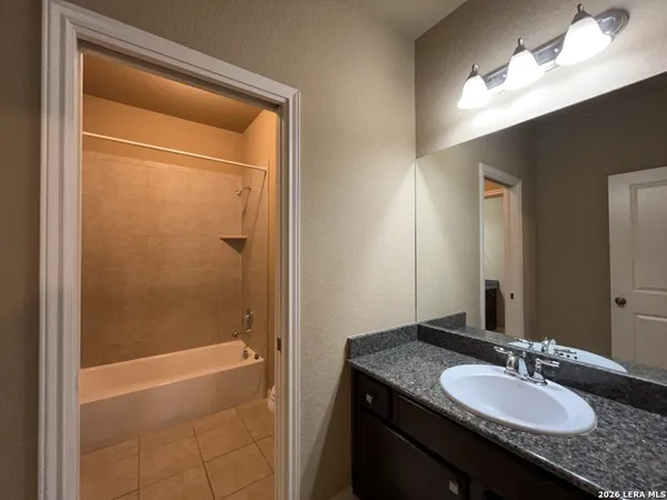 a view of yellow house with large windows and plants