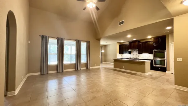 a large kitchen with kitchen island a large counter top stainless steel appliances and cabinets