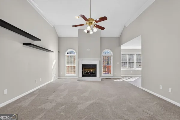 a view of an empty room with a fireplace and a window