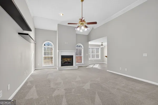 a view of livingroom with fireplace chandelier fan and window