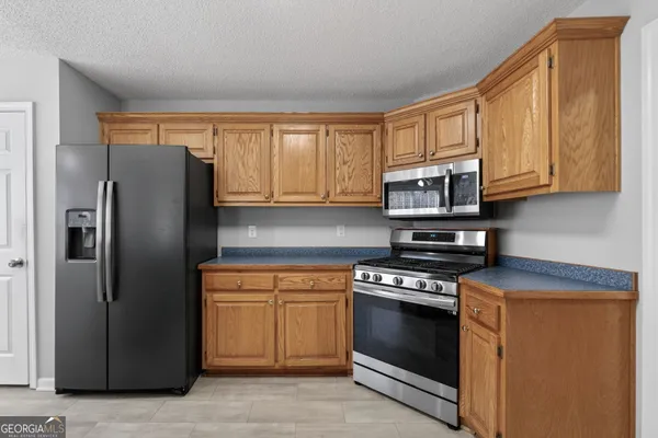 a kitchen with stainless steel appliances granite countertop a stove a refrigerator and a microwave
