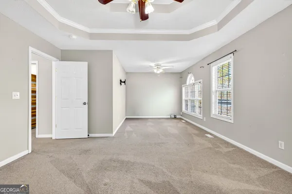 a view of an empty room with window and bathroom