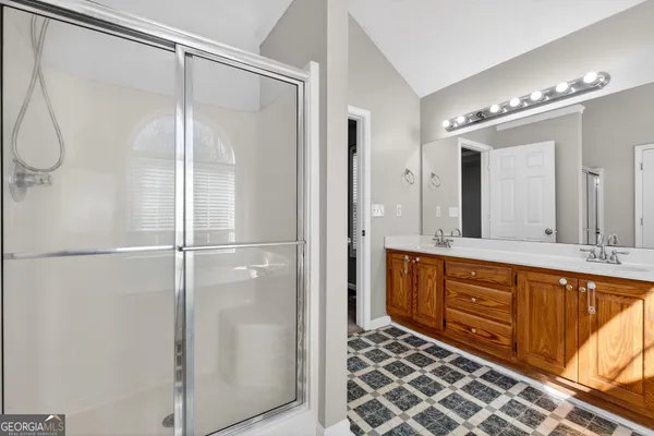 a bathroom with a double vanity sink a mirror and a shower