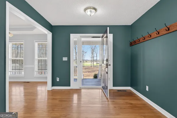 an empty room with wooden floor and windows