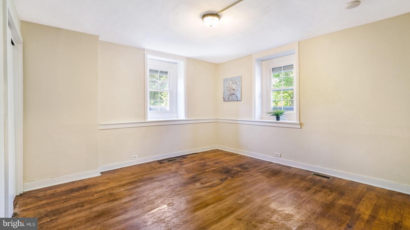 4564 Durham Road, Unit B Doylestown, PA 18902 - Photo 8 of 13 an empty room with wooden floor and windows