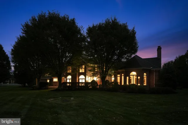 a front view of a house with a yard and green space