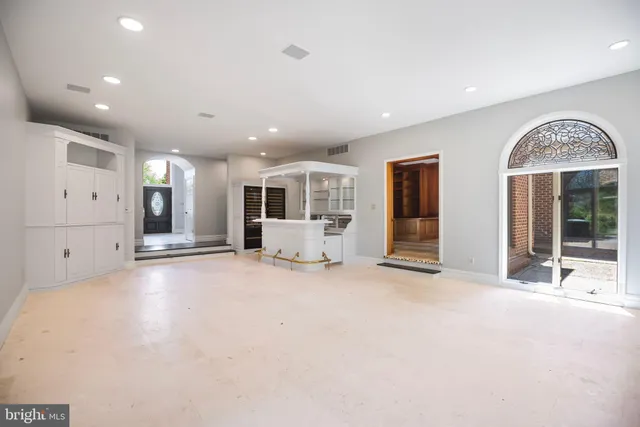 a large white kitchen with granite countertop a large window