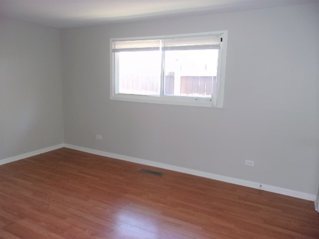 3936 169th Street Country Club Hills, IL 60478 - Photo 6 of 11 a view of an empty room with wooden floor and a window
