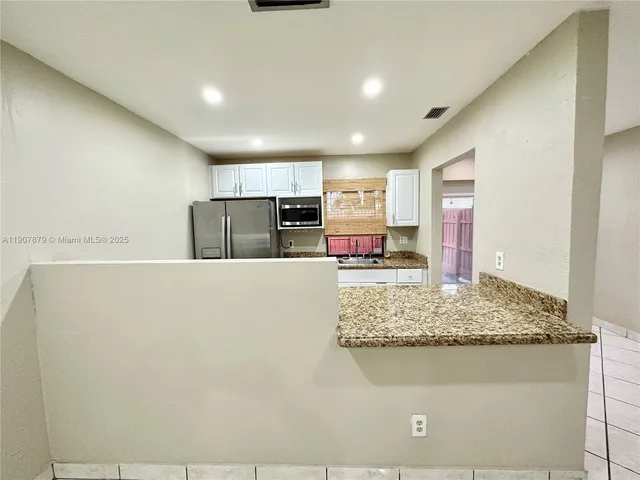 a kitchen with granite countertop a sink and a stove top oven