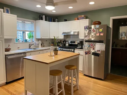 a kitchen with stainless steel appliances a sink a counter top space cabinets and a window