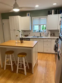 a kitchen with stainless steel appliances granite countertop a table chairs sink and cabinets