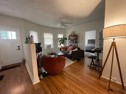 a living room with furniture a wooden floor and a large window