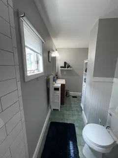 a bathroom with a granite countertop toilet sink and mirror