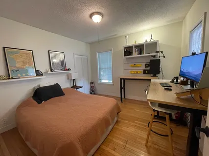 a bedroom with a bed window and table