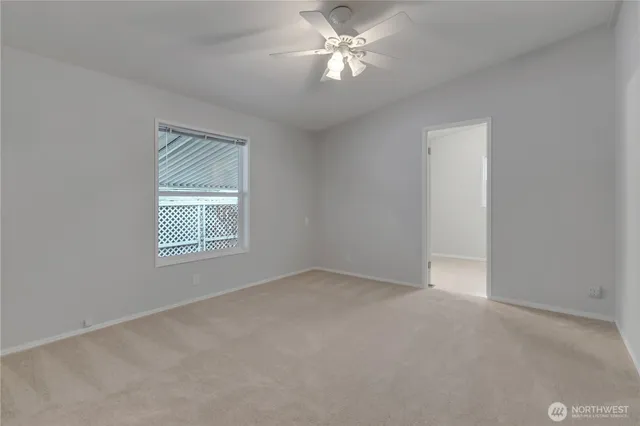 an empty room with a window and a fan