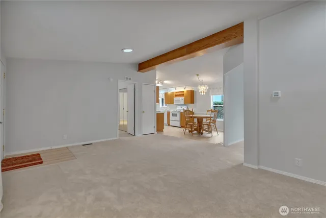 a view of a livingroom with a staircase and a kitchen view