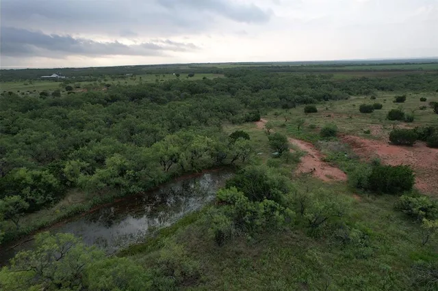 an aerial view of a house with a yard and lake view