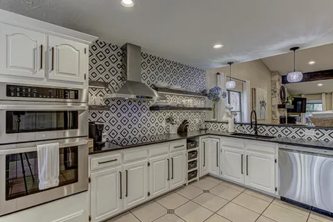a kitchen with white cabinets and appliances