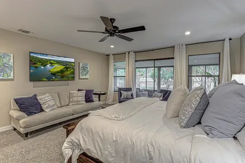 a bedroom with a large bed couch and window