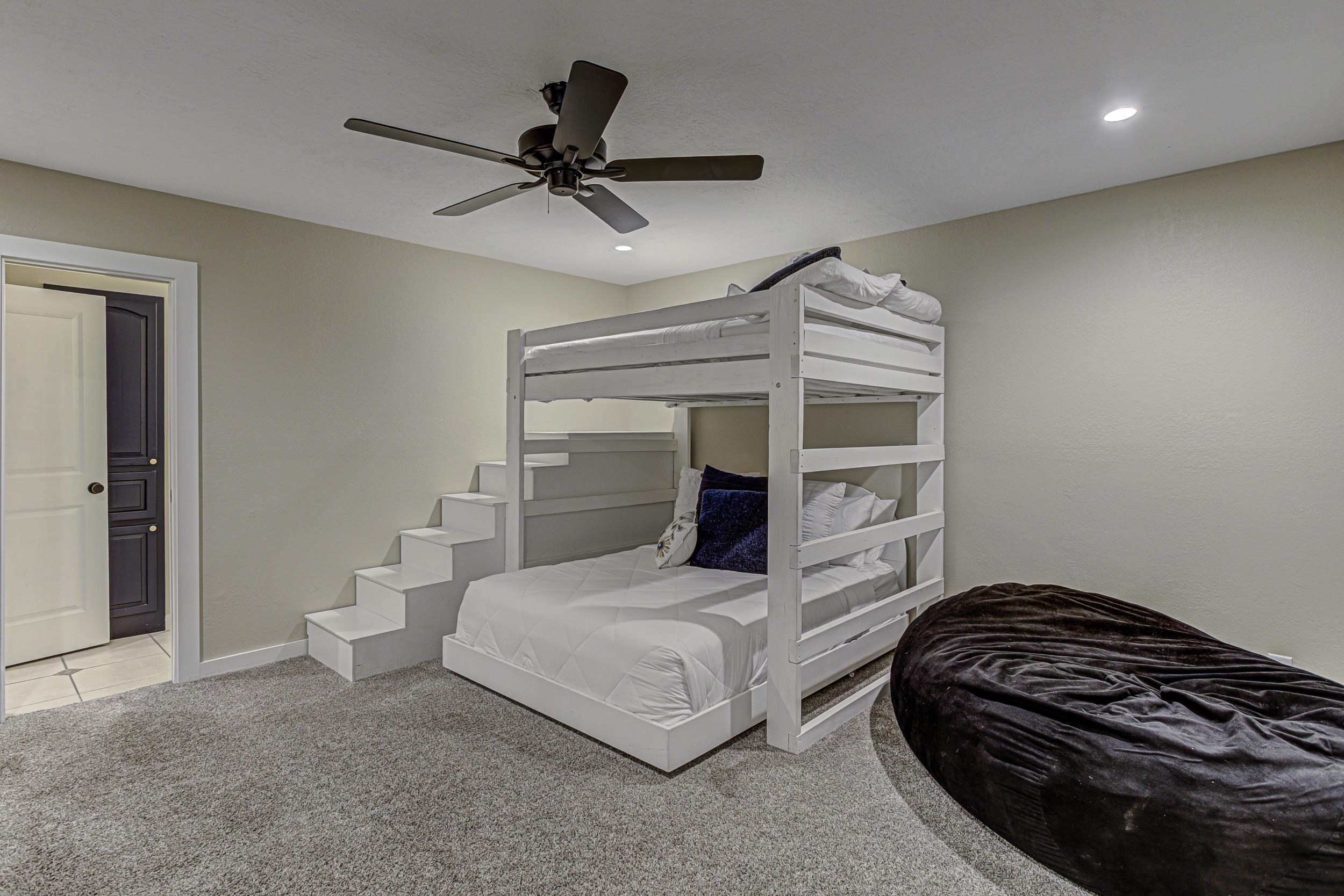 103 Oasis, Unit A Horseshoe Bay, TX 78657 - Photo 23 of 30 a bedroom with a bed and a chandelier