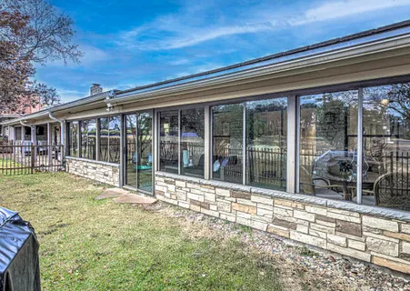 a view of a house with a large window and plants