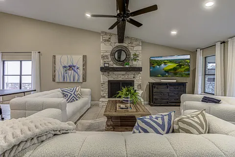 a living room with furniture a fireplace and a chandelier