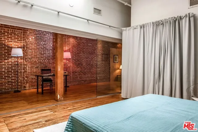 a bedroom with a bed and wooden floor