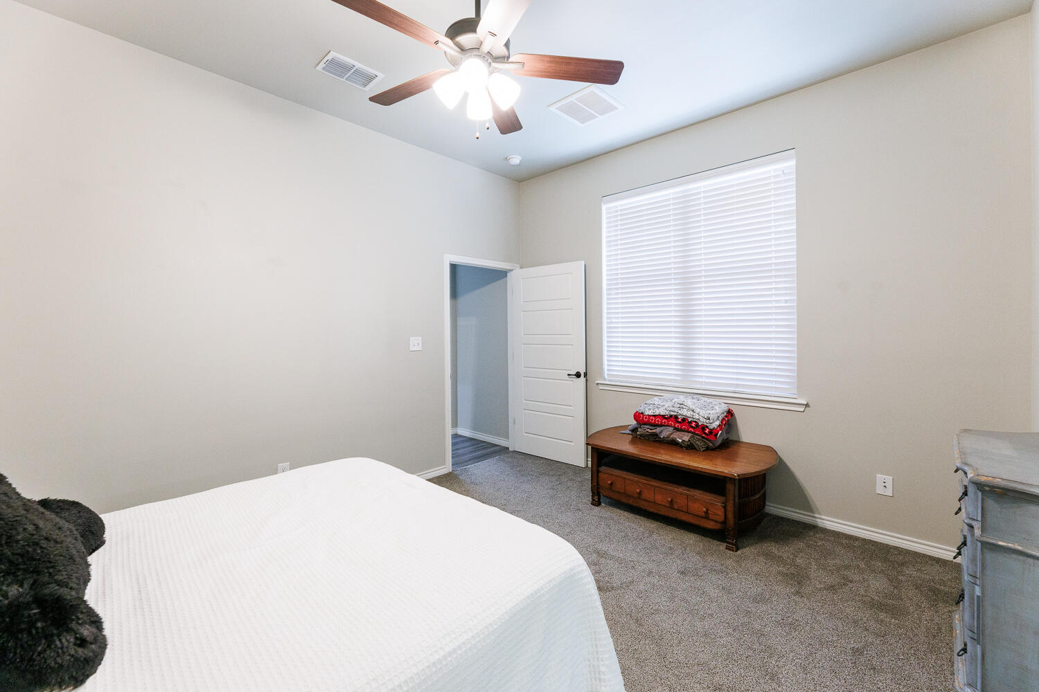 7619 59th Street Lubbock, TX 79407 - Photo 23 of 33 a bedroom with a bed and a chandelier