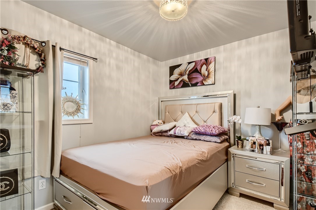 2750 Diamond Loop, Unit E Milton, WA 98354 - Photo 9 of 13 a bedroom with a bed and a chandelier