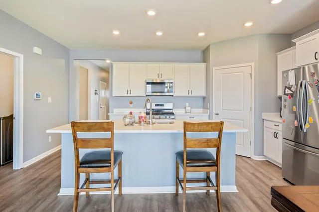 a kitchen with a sink white cabinets and stainless steel appliances