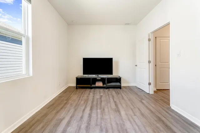 a view of a room with wooden floor and tv