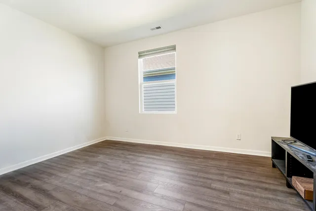 a utility room with wooden floor washer and dryer