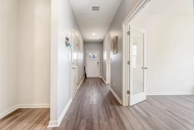 a view of a hallway with wooden floor